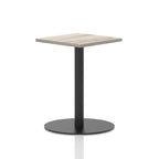 Square table with a grey wood-effect top and black cylindrical base on a white background