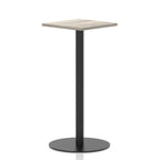 Square high table with a grey wood-effect top and black cylindrical base on a white background