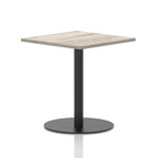 Square table with a grey wood-effect top and black cylindrical base on a white background
