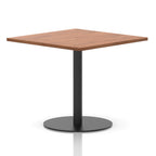 Square table with a wood-effect top and black cylindrical base on a white background