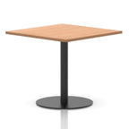 Square table with a wood-effect top and black cylindrical base on a white background