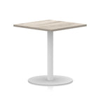 Square table with wood-effect top and white round base on a white background