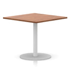 Square table with wood-effect top and white round base on a white background