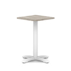 Square table with grey wood-effect top and white metal base on a white background