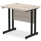 Grey wood-effect desk with cantilever metal legs on a white background