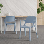 Two light blue plastic dining chairs with armrests, shown in a modern room setting with a white marble-patterned wall, a light wood table, and a speckled grey floor.