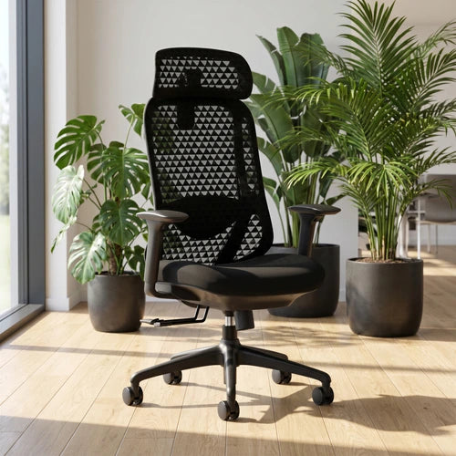 A black mesh office chair with a high back, geometric triangular pattern, and five-wheel casters, positioned in a bright room with potted plants and a wooden floor.