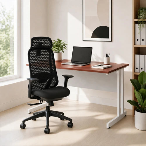 A black mesh ergonomic office chair with a five-wheel base is positioned in front of a wooden desk with a white metal frame in a bright, modern home office setting.