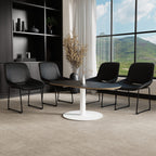 A modern dining set featuring a round black-top table with a white pedestal base, surrounded by four black upholstered chairs in a contemporary room with a large window overlooking green hills.
