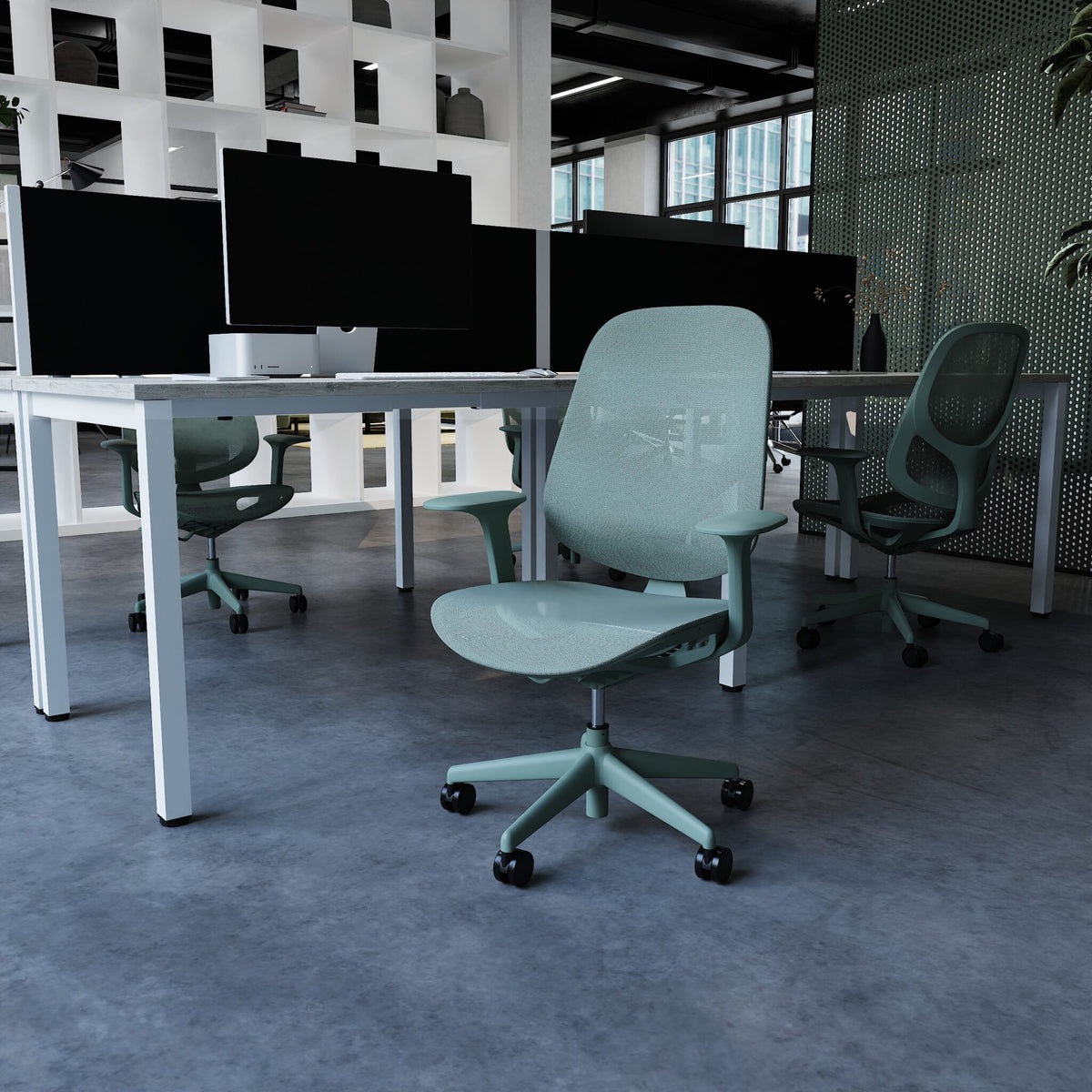 A blue ergonomic office chair with a mesh back and five-star wheeled base, positioned in front of a desk with multiple computer monitors in a modern office setting.