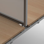 Close-up of a modular office partition or desk cubicle system with light wood grain panels and a silver metal frame on a white background.