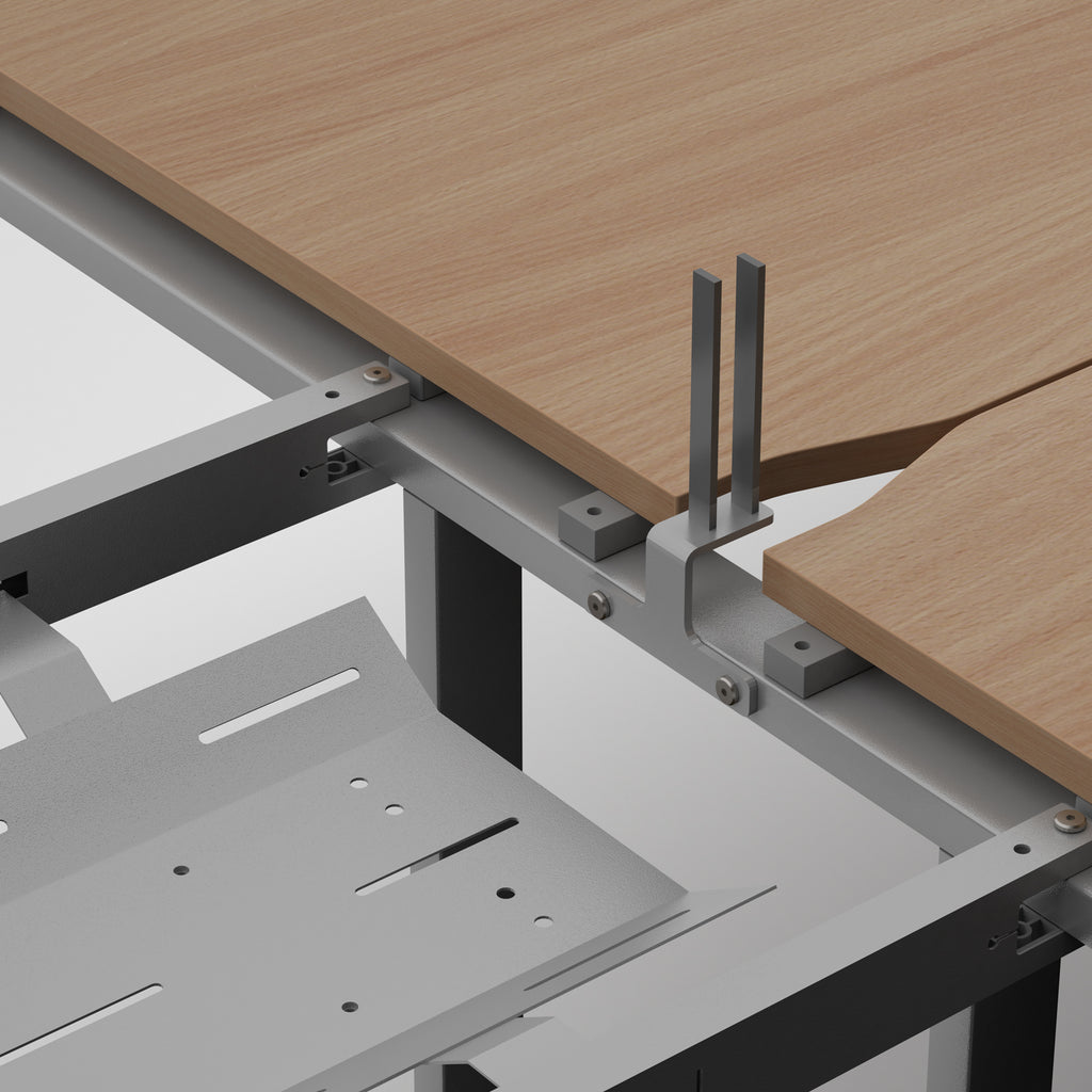 Close-up of a desk frame showing a light wood desktop, metal support brackets, and a gray desk base against a white background.