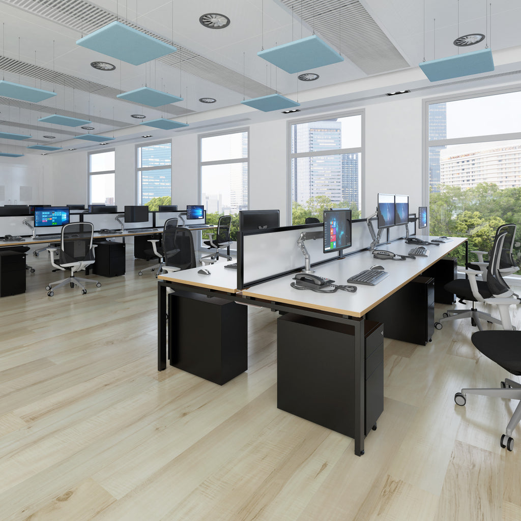 Modern office with desks, chairs, and computer monitors in a well-lit room.