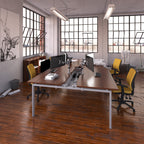 Modern office space with a large desk, chairs, and large windows.