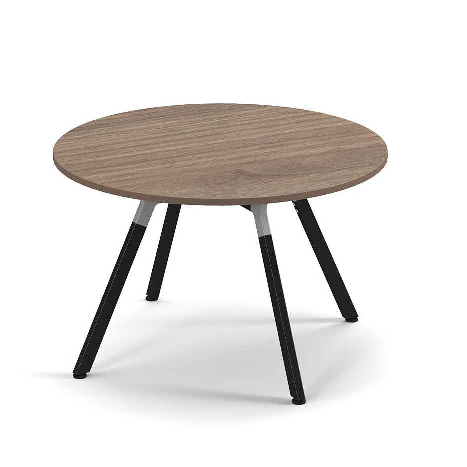 A round coffee table with a medium brown wood-grain top and four black tapered metal legs, shown on a clean white background.