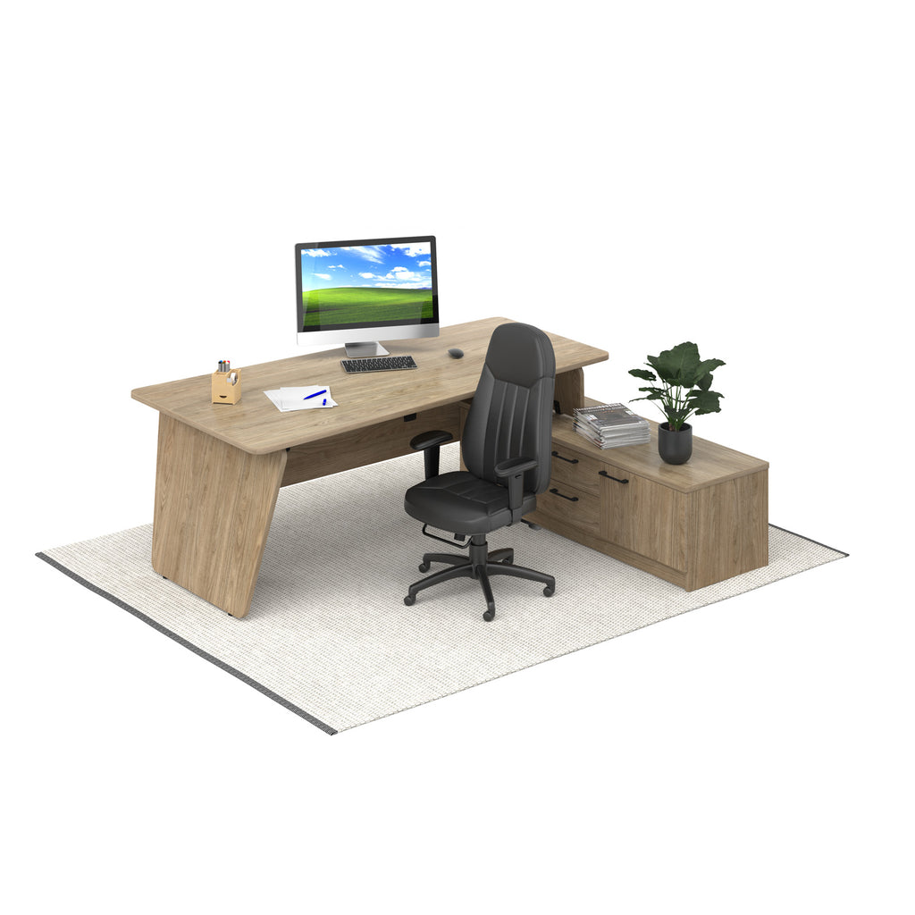 A modern L-shaped office desk with a light walnut wood grain finish, paired with a black ergonomic office chair and a matching side cabinet, shown on a white background with a light grey rug.