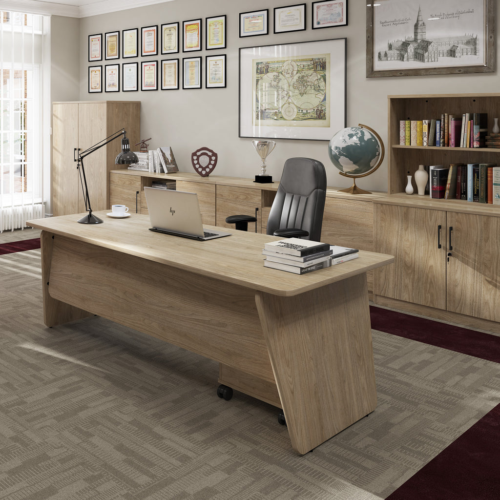 Wooden office desk with a chair, laptop, and decor in an office setting.