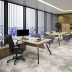 Modern office interior with a light wood desk, black office chair, computer monitor, grey chairs, and large vertical blinds over a city view.