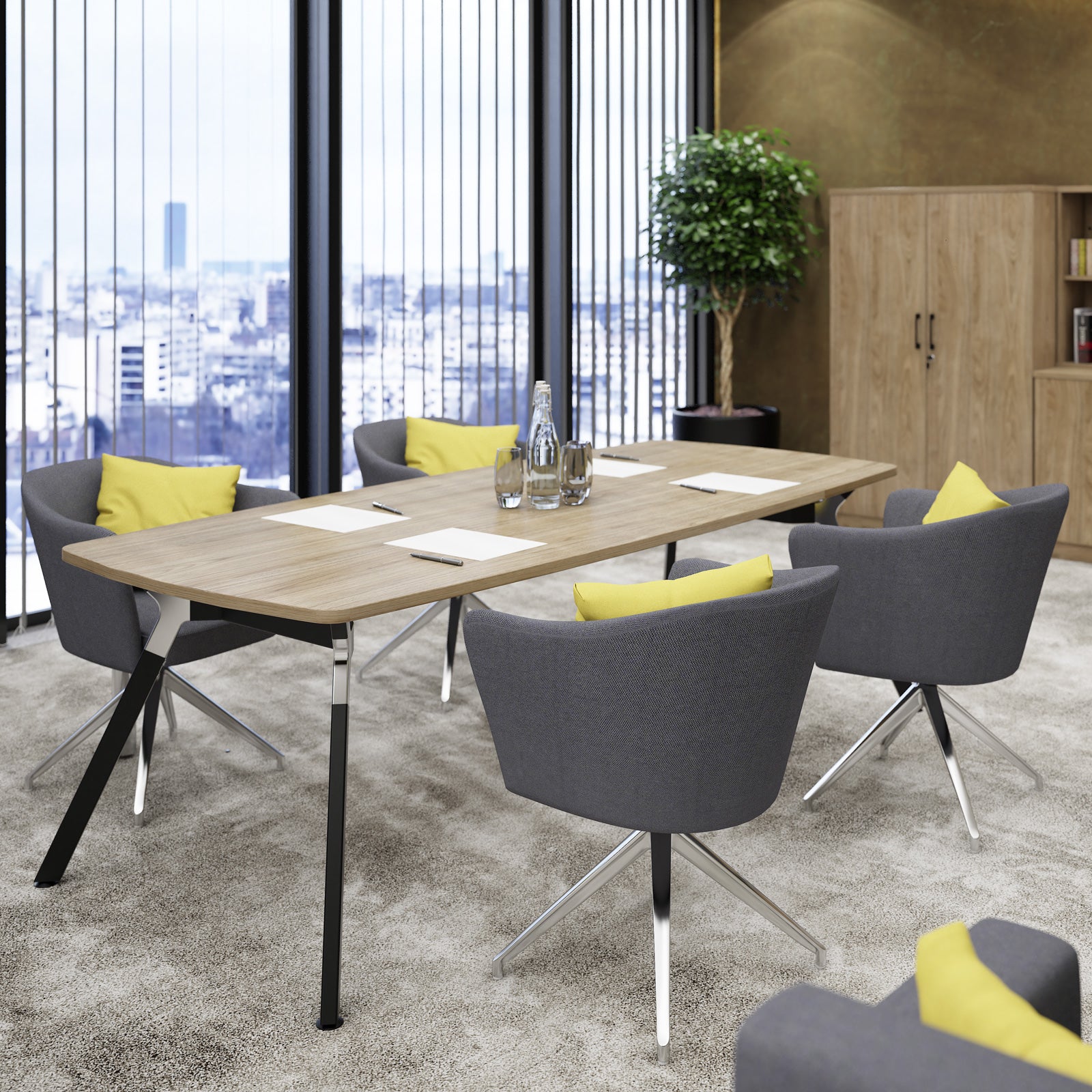 A modern meeting room setup featuring a rectangular wooden conference table with black metal legs, surrounded by six gray swivel chairs with yellow accent pillows. The room has a large window overlooking a city skyline, a potted tree, and a wooden cabinet in the background.