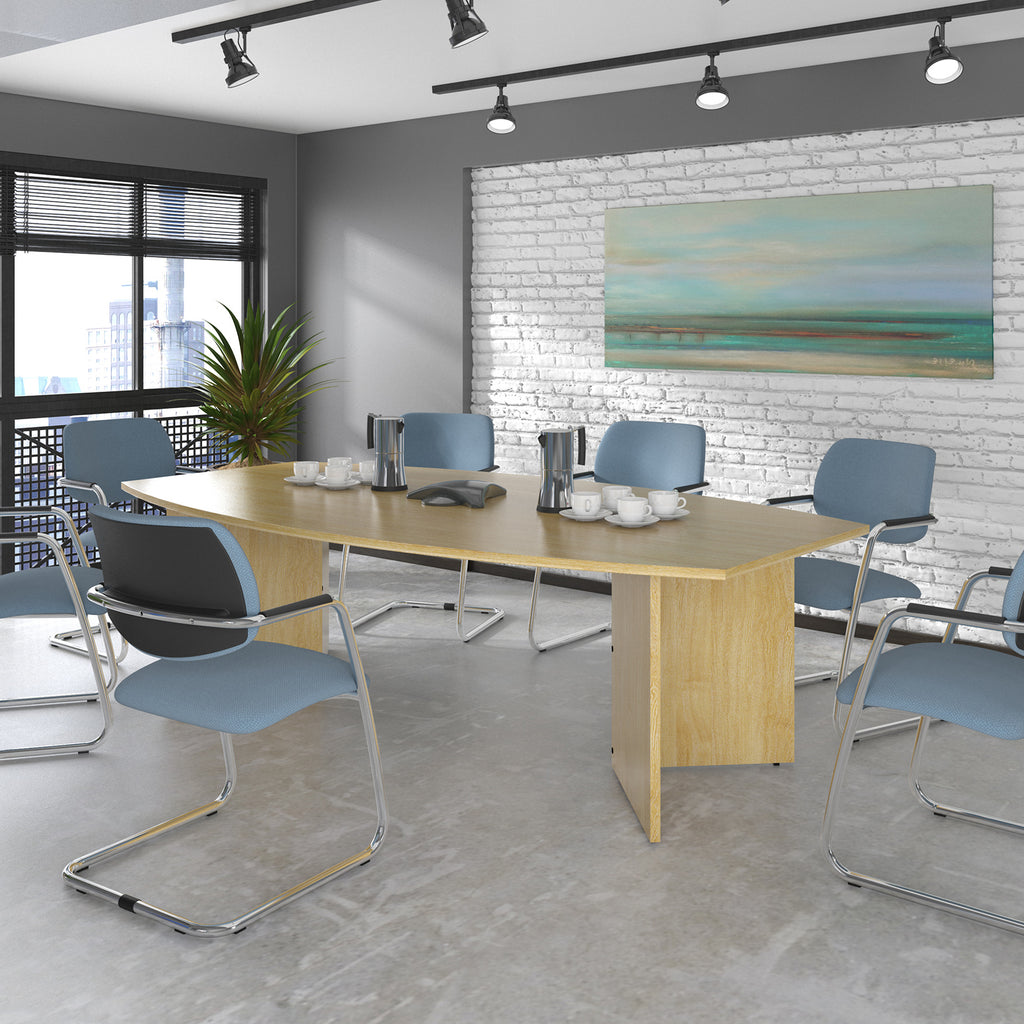 Modern conference room with a wooden table and blue chairs against a white brick wall.