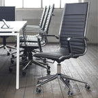 Black office chairs in a modern office setting with a table and tablet.