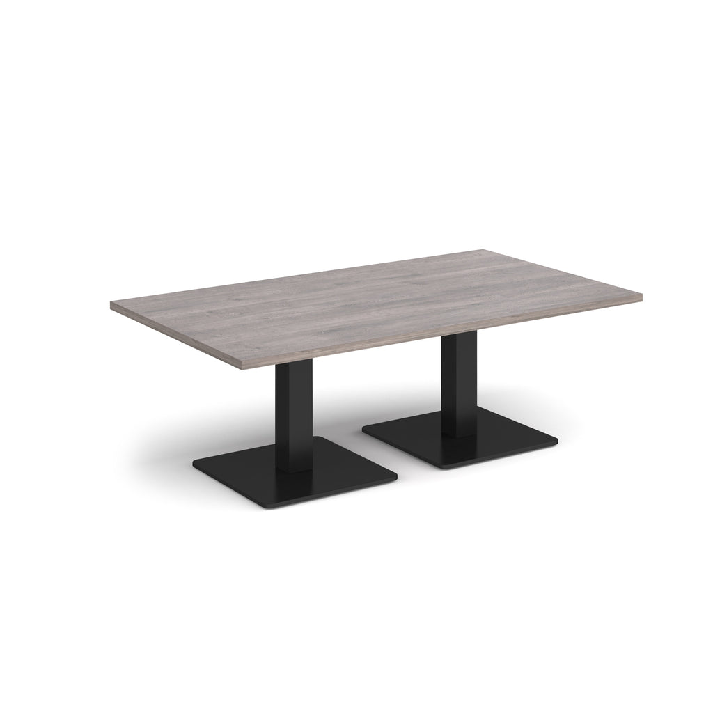 Rectangular coffee table with grey wood-effect top and two black metal square bases, shown on a white background