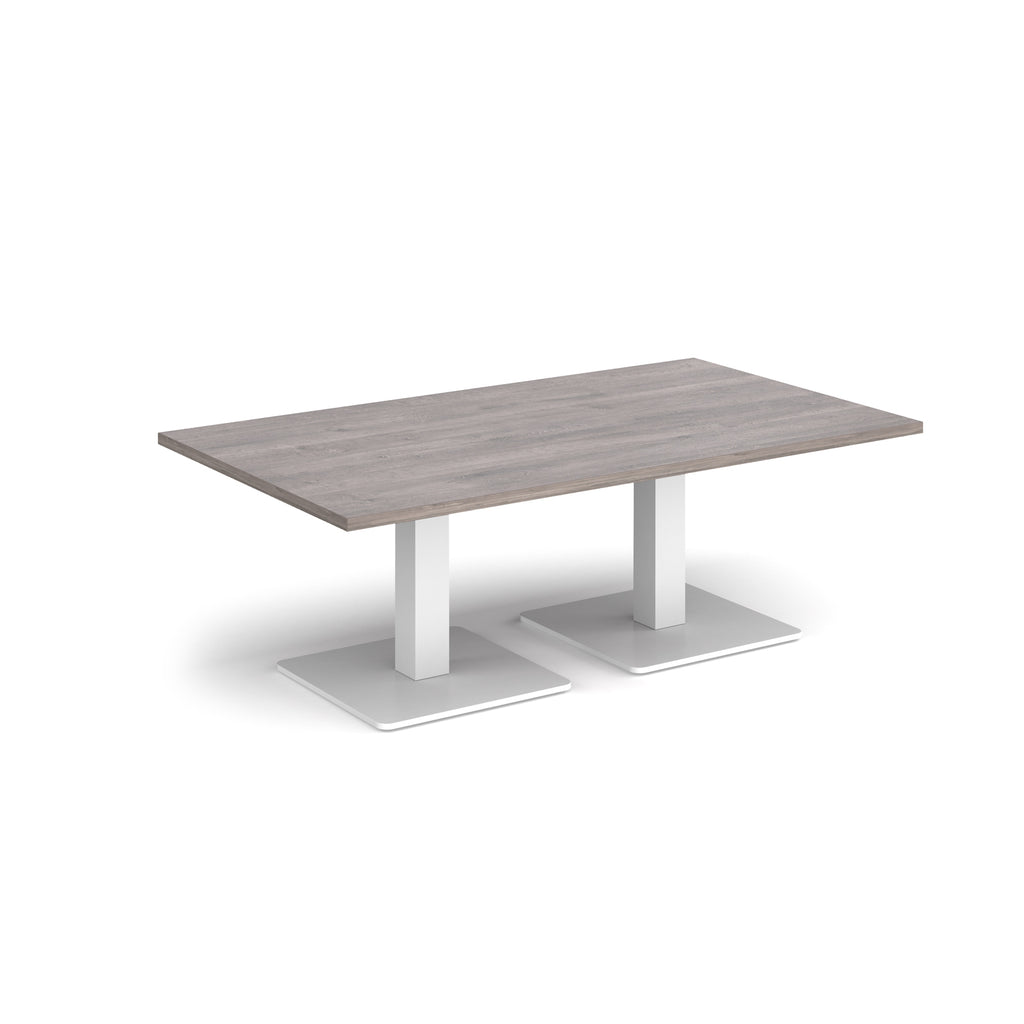 Rectangular coffee table with grey wood-effect top and two white metal square bases, shown on a white background