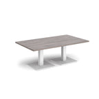 Rectangular coffee table with grey wood-effect top and two white metal square bases, shown on a white background