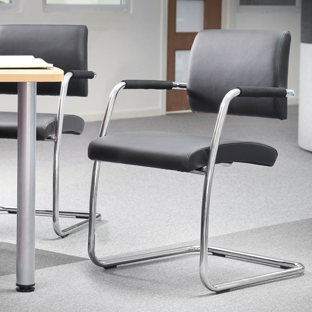 Office chairs with metal frames around a table in an office setting