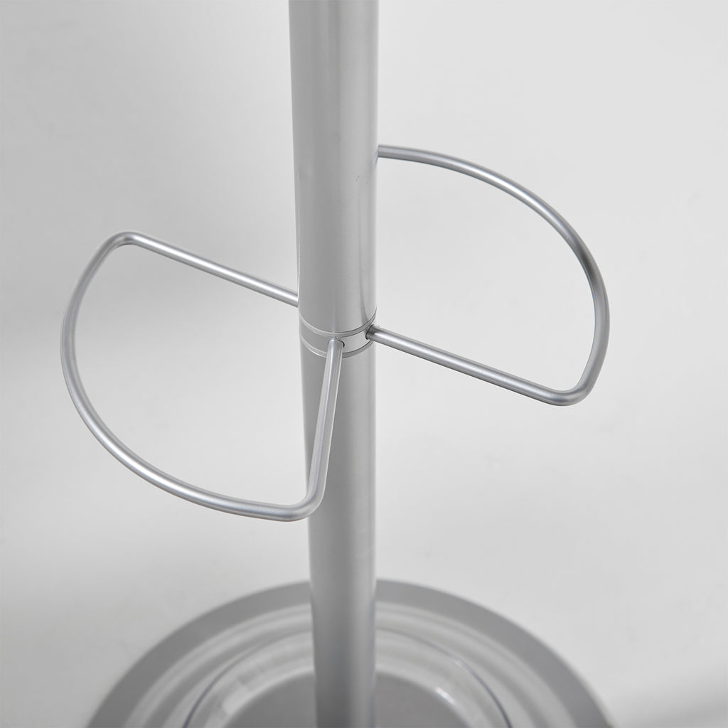 A close-up of a metallic silver metal stand with a central vertical pole and two curved support loops, set against a plain light gray background.