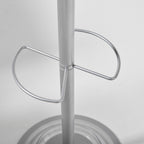 A close-up of a metallic silver metal stand with a central vertical pole and two curved support loops, set against a plain light gray background.