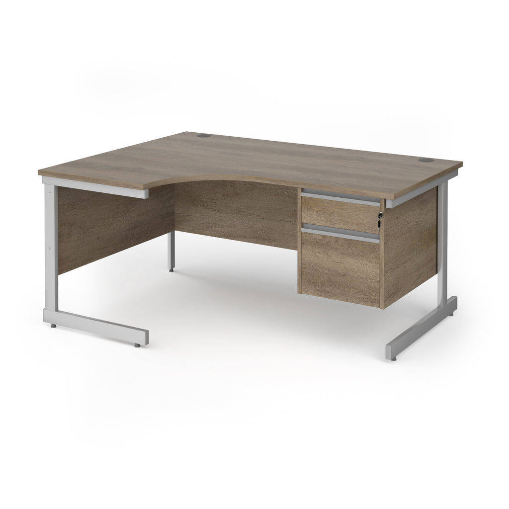 Corner office desk with a light brown/grey wood grain finish and a silver metal frame, featuring two drawers on the right side.