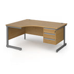 Corner office desk with a light oak wood grain finish and a dark grey metal frame, featuring three drawers on the right side.