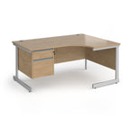 Corner office desk with a light oak wood grain finish and a silver metal frame, featuring two drawers on the left side.