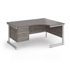 Corner office desk with a grey wood-grain finish and a white metal frame, featuring a three-drawer pedestal on the left side.