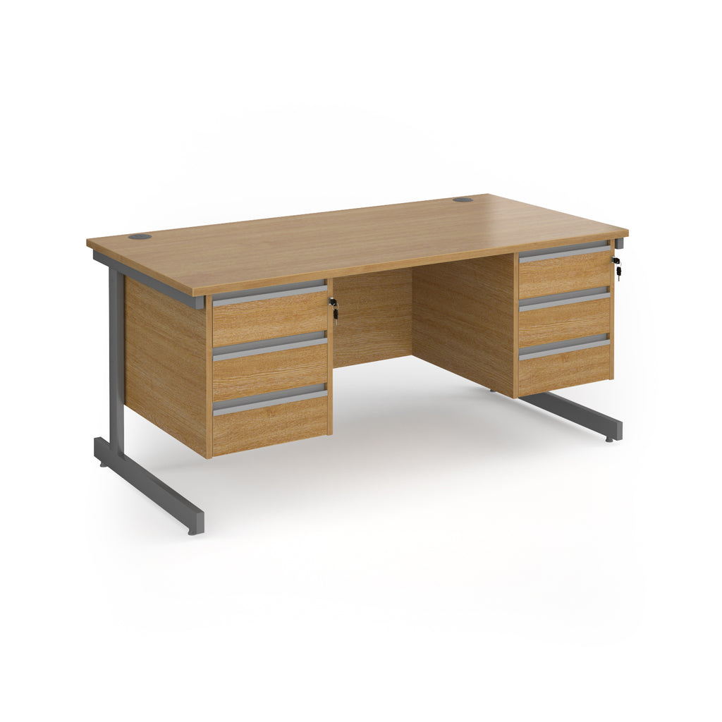 A modern office desk with a light oak wood grain finish and dark grey metal legs, featuring three drawers on the left and three drawers on the right.