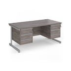 A modern office desk with a grey wood grain finish and silver metal legs, featuring three drawers on the left and three drawers on the right.