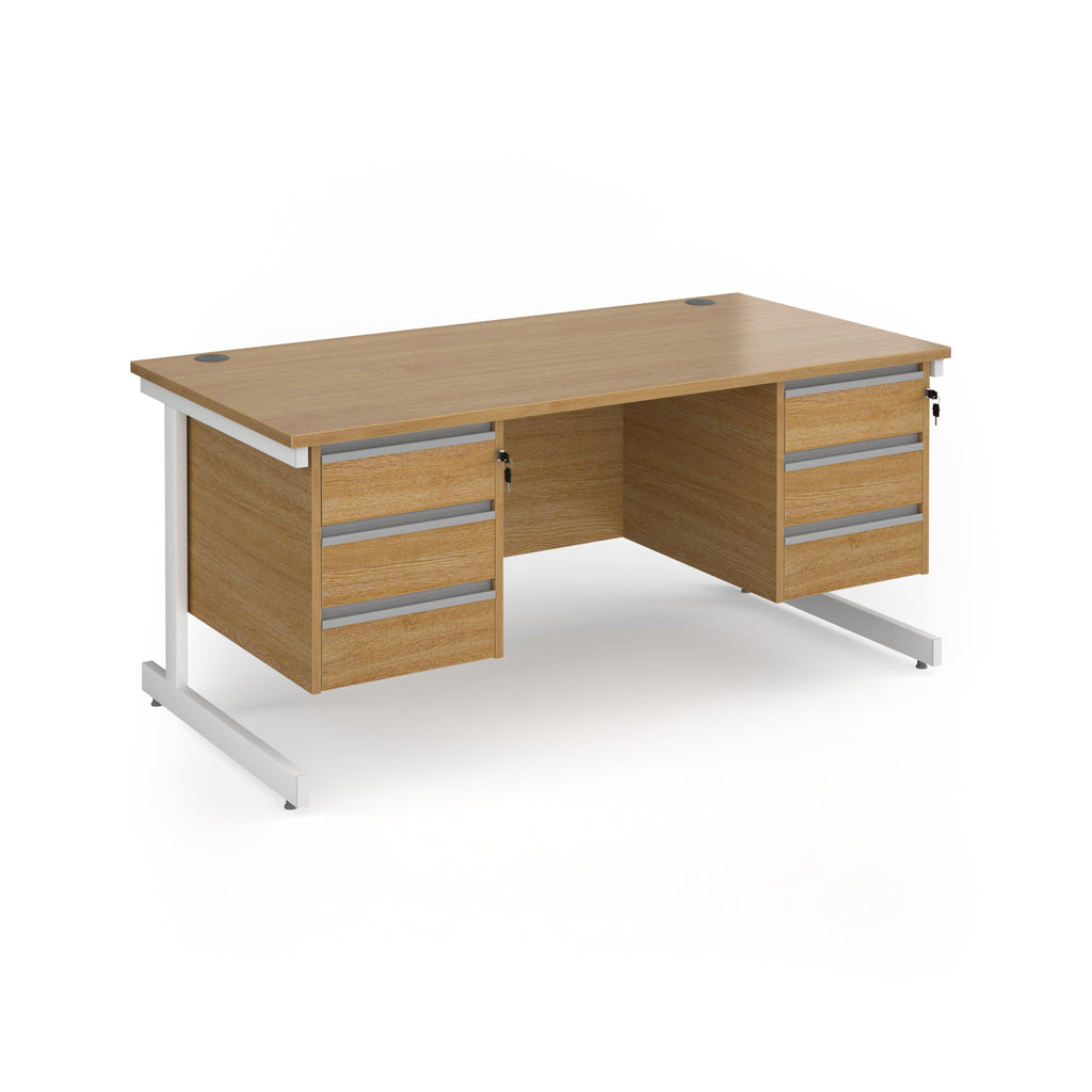 A modern office desk with a light oak wood grain finish and white metal legs, featuring three drawers on the left and three drawers on the right.