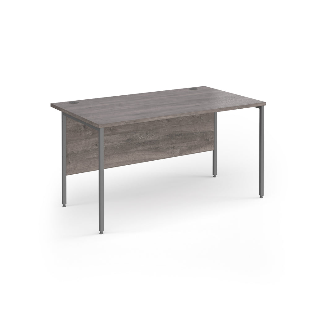 A rectangular office desk with a grey wood-effect top and matching modesty panel, supported by slim grey metal legs, shown on a white background.