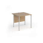 A square office desk with a wood-effect top and matching modesty panel, supported by slim silver metal legs, shown on a white background.