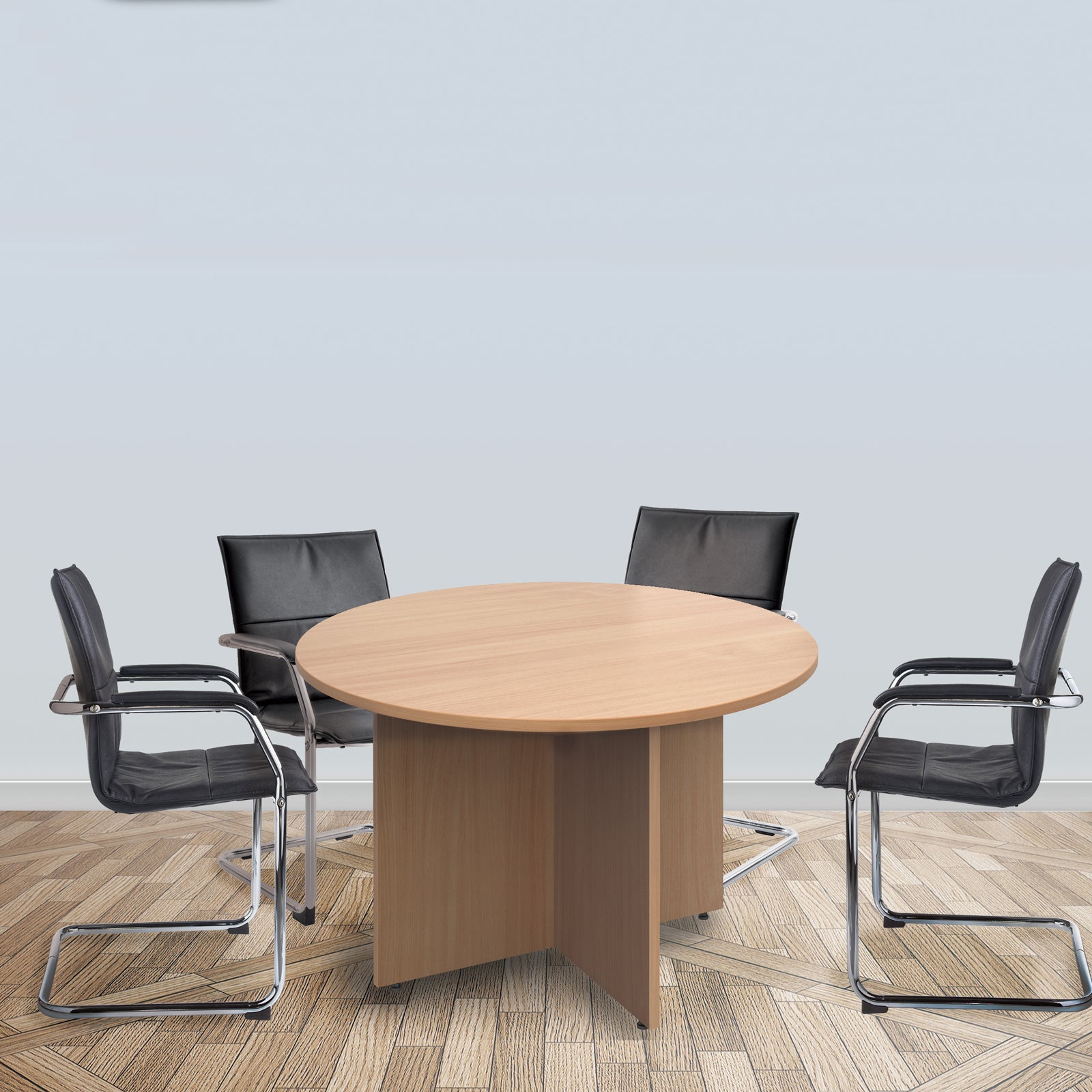 Round meeting table with a light wood-effect finish and panel base, surrounded by black meeting chairs in a modern meeting room setting.
