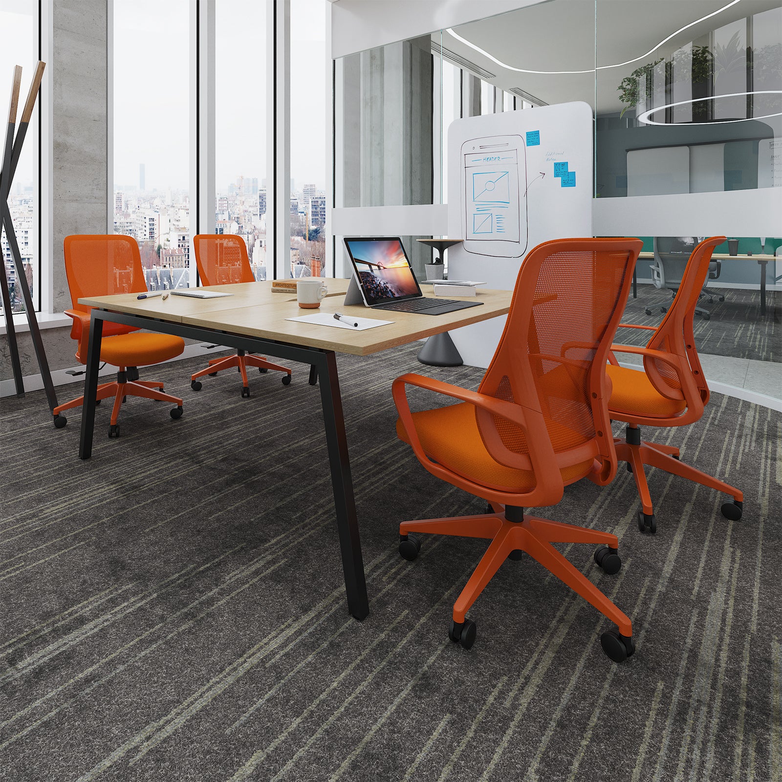 Modern office space with orange chairs and a desk.