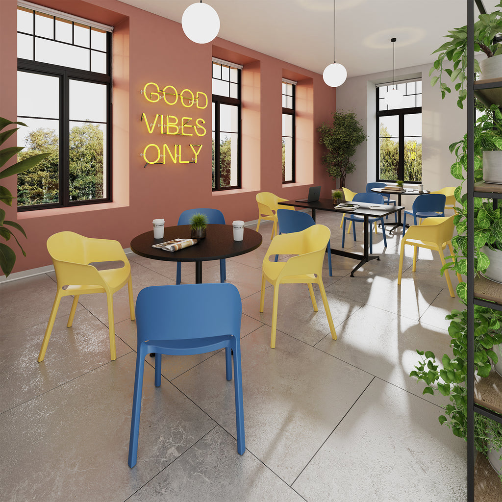 Modern interior with blue and yellow chairs, a neon sign, and large windows.