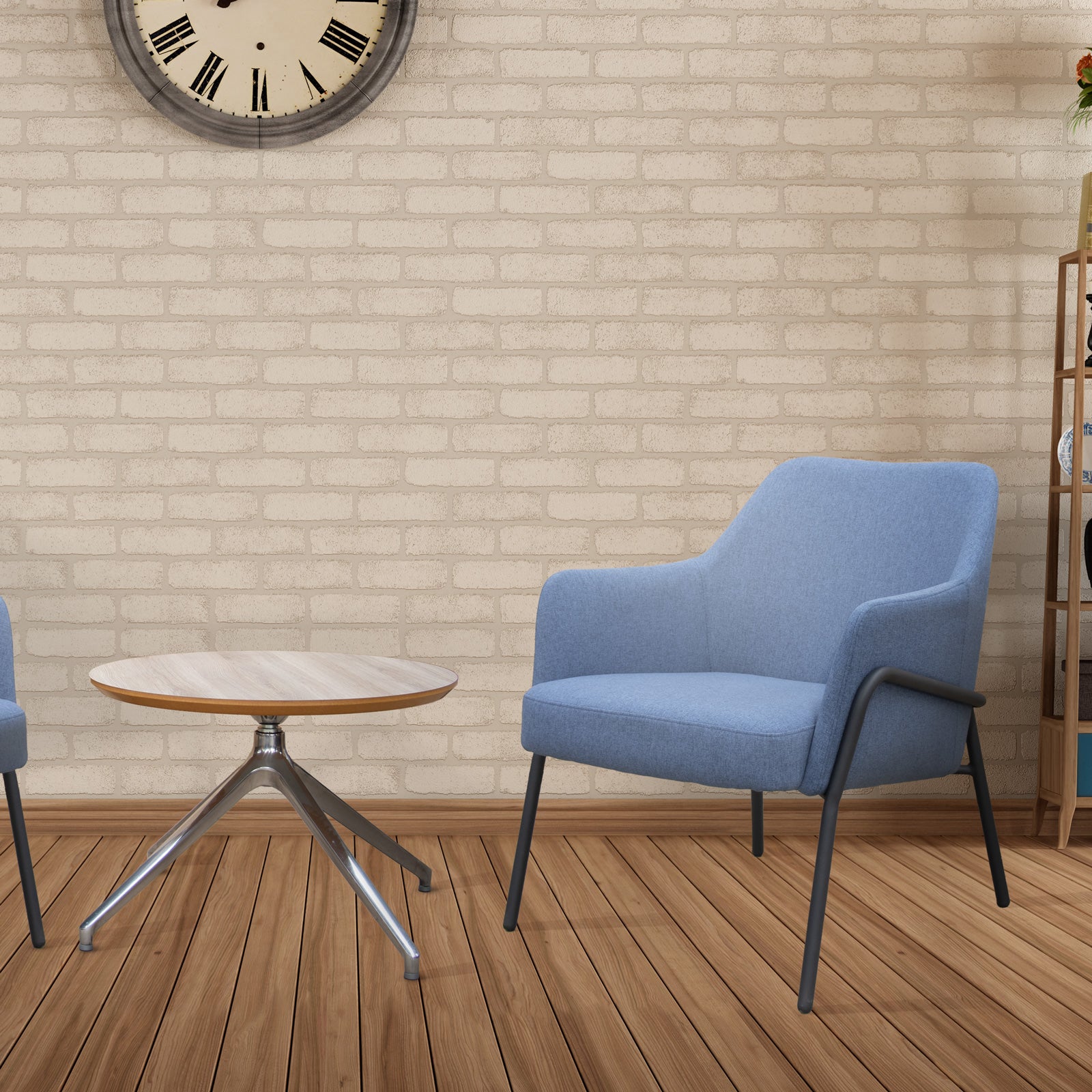 Blue armchair and small round table in a room with wooden flooring and brick wall.