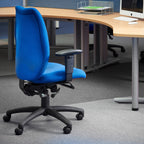 Blue office chair in an office setting with desks and computers.