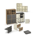 Modular storage cabinet system with cube shelving units, drawers, and doors in mixed wood, grey, and cream finishes, shown assembled and disassembled on a white background.