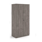 A tall two-door cabinet with a grey wood grain finish, featuring two vertical doors with slim silver handles and small lock keys, shown on a plain white background.