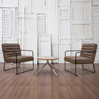 Two brown chairs with black frames and a small round table in a room with white paneled walls.