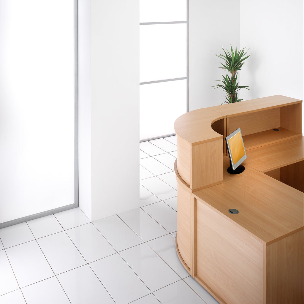 Wooden reception desk with a screen in a bright office setting
