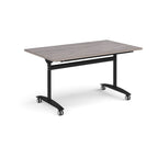 Rectangular table with a grey wood-effect top and black metal legs with castors on a white background